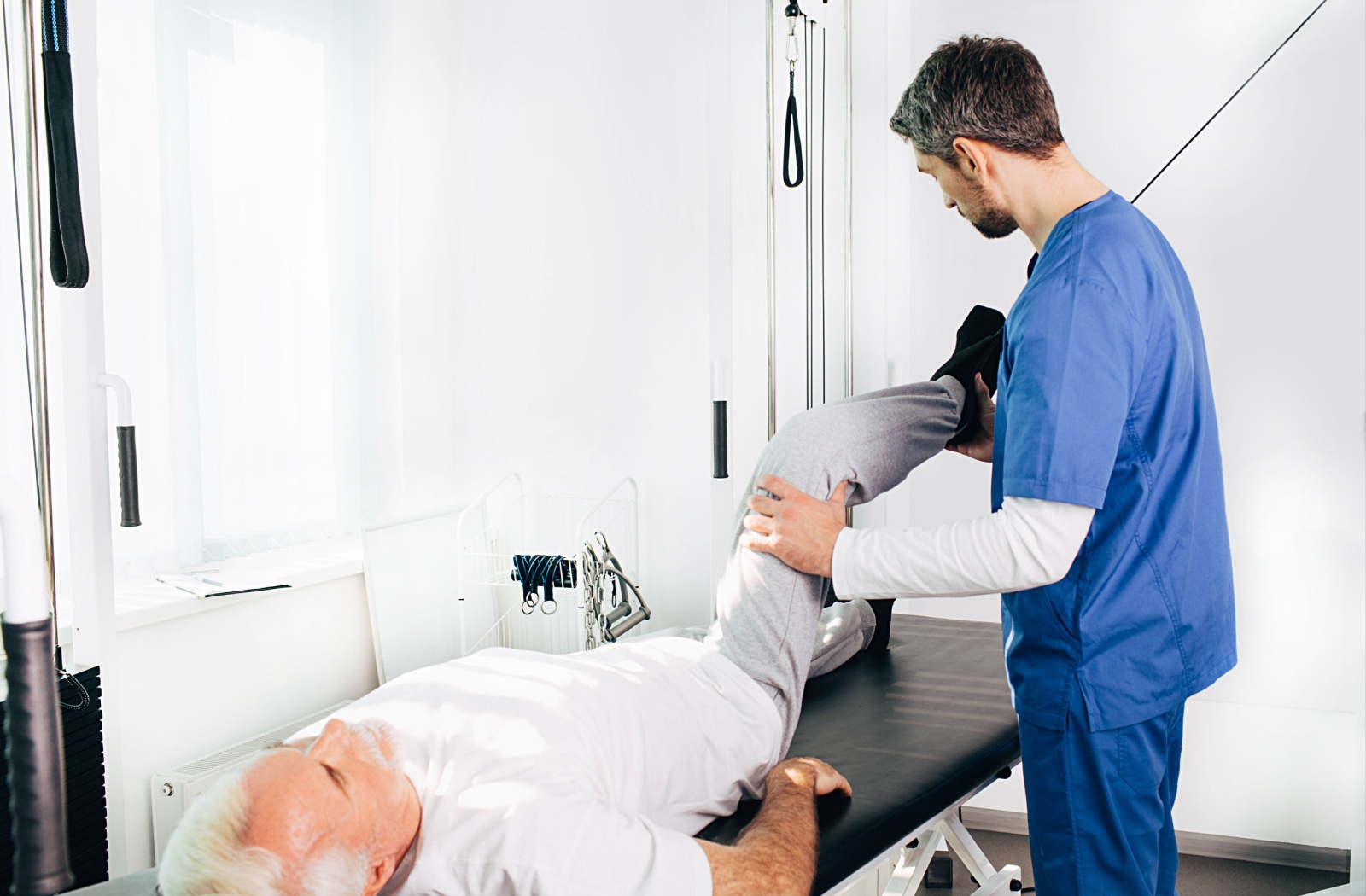 Senior patient receiving kinestherapy treatment on hips.