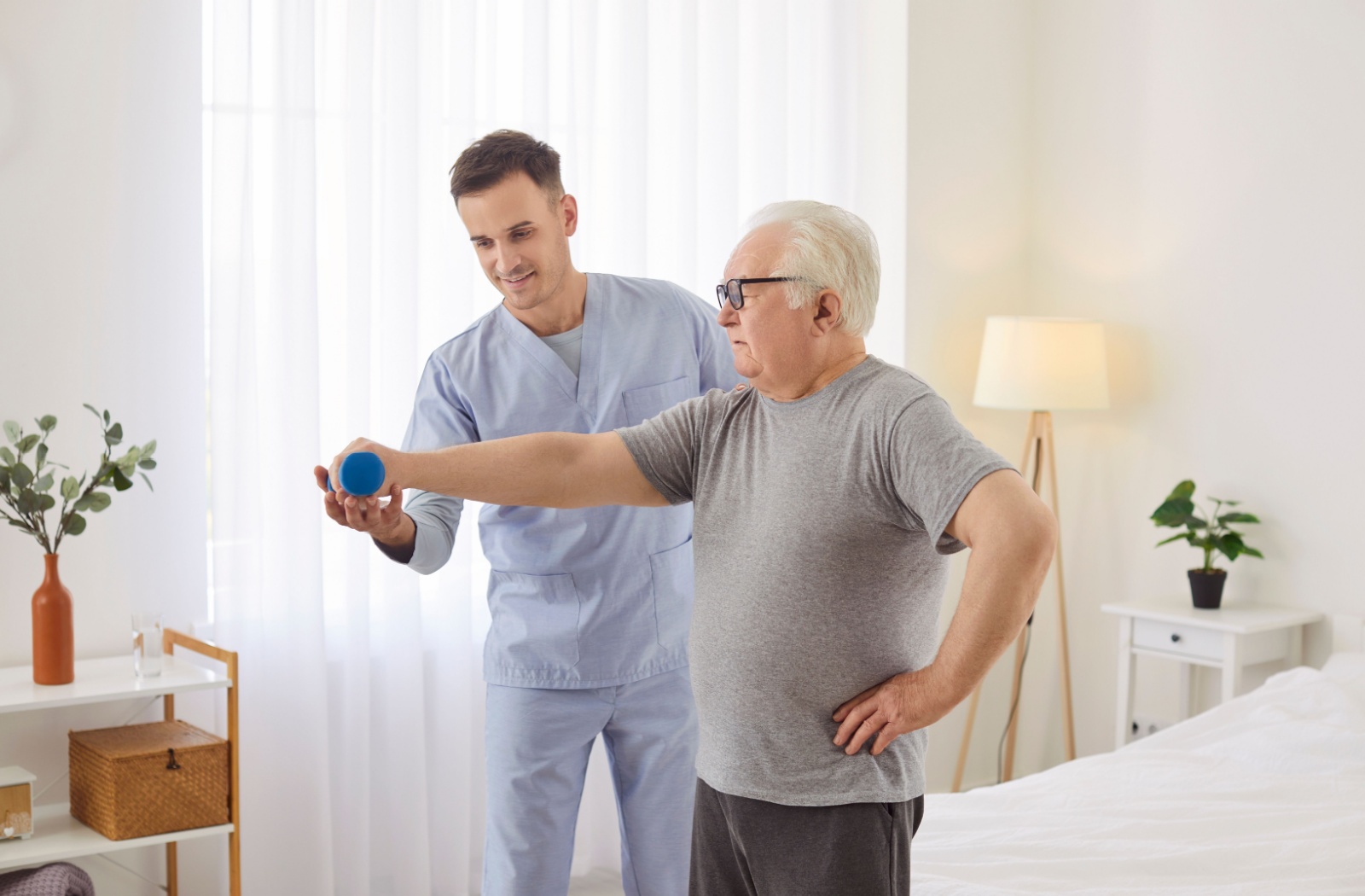 A senior works on occupational therapy exercises with a caregiver