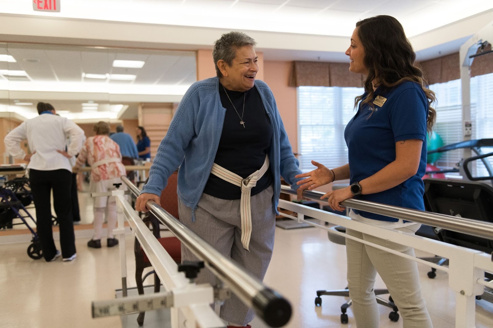 A physical therapy assistant at a Kingston Healthcare community assists a resident through a rehabilitation plan